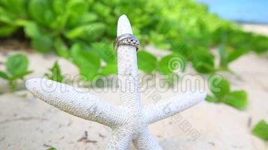 结婚戒指和海星海滩爱情概念